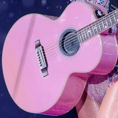 a close up of a person holding a pink guitar