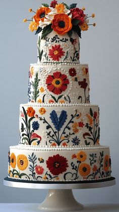 a multi layer cake decorated with flowers and beads