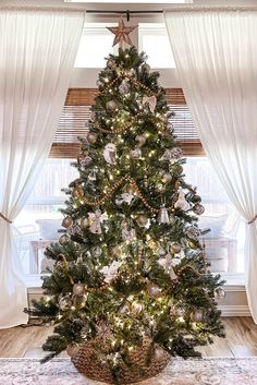 a decorated christmas tree in front of a window