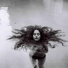 a woman with long hair standing in the water