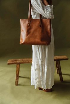 Discover the perfect everyday companion with the Simple Leather Tote by WP Standard. Made from 100% full-grain leather, this vintage tote is not only reliable but also ages beautifully with time and use. With a spacious 15" width and 13" height, it offers both style and practicality. Leather Tote Bag Outfit, Tote Bag Outfit, Vintage Tote Bag, Wardrobe Wishlist, Spring Styles, Fun Clothes, Leather Tote Bags, Simple Leather