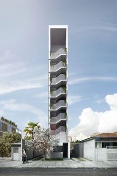 a tall building with plants growing on it's side in the middle of a street