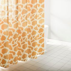 an orange and white shower curtain in a bathroom with tile flooring next to a bathtub