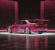 a pink car is parked in an empty parking garage with its hood up and lights on