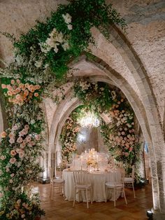 a table with flowers and candles is set up in an archway for a formal function