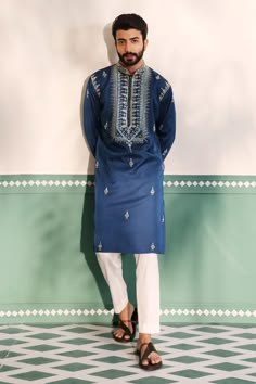 Teal blue kurta with geometric embroidered placket in cutdana, beads and mirror work. Paired with a pant.
Components: 2
Pattern: Embroidery
Type Of Work: Geometric, Beads, Cutdana
Neckline: Stand Collar
Sleeve Type: Full Sleeves
Fabric: Padma Silk
Color: Blue
Other Details: 
Embroidered buttis on kurta
Arm-hole embroidery in cutdana and beads
Note: The red kurta set worn by the other model is not for sale
Occasion: Sangeet - Aza Fashions Kurta With Hand Embroidery, Men Embroidery Kurta Design, Panjabi For Men, Sangeet Outfit For Men, Designer Kurta For Men, Traditional Indian Mens Clothing, Hole Embroidery, Indian Menswear, Kurta Designs Men's