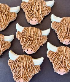 decorated cookies shaped like cows with long hair on them are arranged in the shape of bison heads