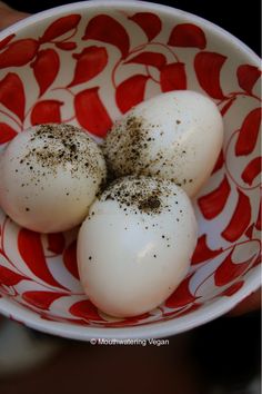 three hard boiled eggs in a red and white bowl