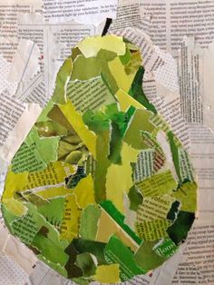 an apple made out of newspaper paper with green and yellow leaves on the inside, sitting on top of a pile of newspapers