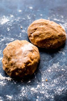 two cookies sitting on top of a table covered in powdered sugar