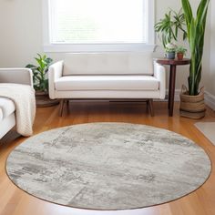 a living room with white furniture and plants