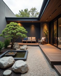 an outdoor living area with rocks, gravel and a bonsai tree