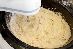 a mixer mixing batter in a black bowl