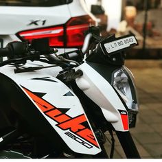 a white and black motorcycle parked next to a car