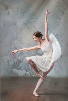 a young ballerina is posing for the camera