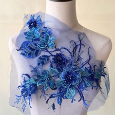 a mannequin with blue flowers on it's chest and some sheer fabric