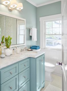 a bathroom with blue cabinets and white fixtures