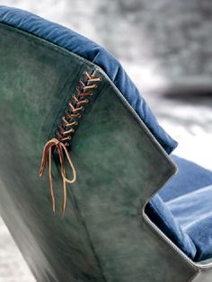 a blue and green chair with a brown lace on it's backrests