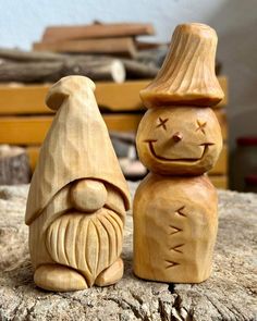 two carved wooden gnomes sitting next to each other