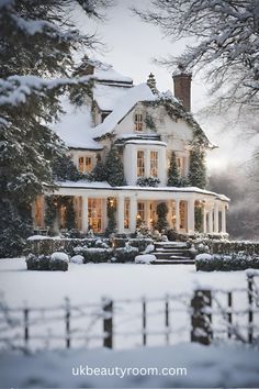 a large white house covered in snow next to trees