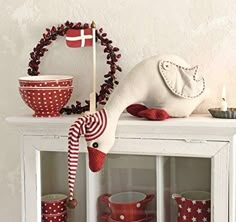 a white shelf topped with lots of red and white dishes