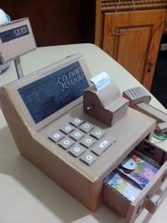 a cardboard model of an old style phone on a table with other items around it