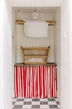 a laundry room with red and white stripes on the floor, hanging clothes from a rack