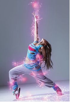 a woman is dancing with her arms in the air and sparkling lights around her head