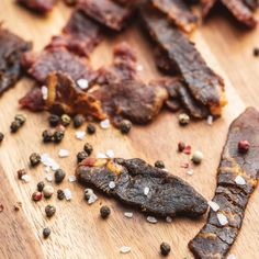 some food that is on top of a wooden cutting board with pepper flakes and seasoning