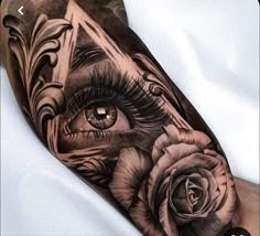 an eye and rose tattoo on the arm