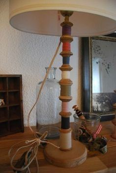 a lamp that is sitting on top of a wooden table next to a glass jar