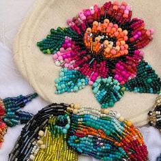 beaded flowers and beads on a white cloth with a circular bag in the background