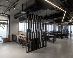 an office with black partitions and wooden chairs