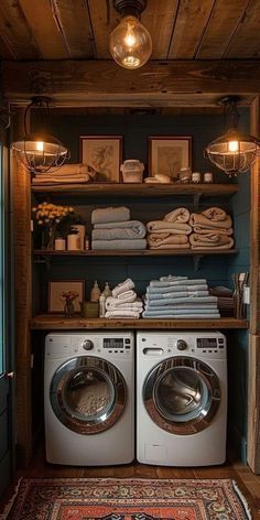 a washer and dryer in a room next to a shelf filled with towels