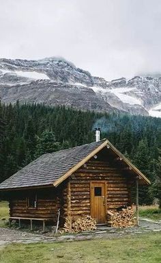 a log cabin in the mountains surrounded by trees