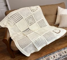 a white crocheted blanket sitting on top of a couch