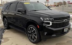 a black suv is parked on the side of the road