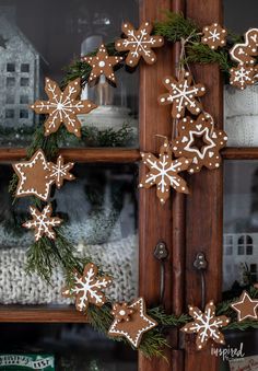 a close up of a christmas wreath on a wooden door with snowflakes