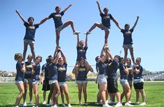 the cheerleaders are posing for pictures on the field with their hands in the air