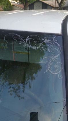 the back window of a car with white designs on it