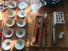 bowls and utensils are sitting on a bamboo mat