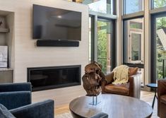 a living room filled with furniture and a flat screen tv mounted on the wall above a fireplace