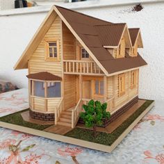 a wooden model of a house sitting on top of a table