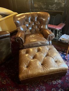 a brown leather chair and ottoman in a living room