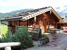 a small wooden cabin sitting on top of a lush green hillside