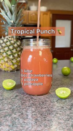 a pineapple drink in a mason jar next to sliced limes on the counter