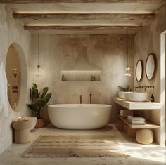 a beautifully designed bathroom that embodies a serene, natural aesthetic. The room features a soft, warm palette, primarily composed of sandy and cream tones. The walls and ceiling display a textured finish, possibly tadelakt or lime plaster. Natural wood elements are evident in the ceiling beams, round mirrors with simple wooden frames, and a slender shelf holding toiletries. Organic touches are added with woven baskets, a jute rug, Bali Inspired Bathroom, Wabi Sabi Bathroom, Zen Bathrooms, Bali Interior, How To Start Painting, Greek Villa, Bohemian Bathroom, Painting Walls, Start Painting