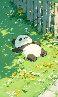 a panda bear laying on the ground in front of a fence and some yellow flowers