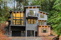 a modern house in the woods surrounded by trees