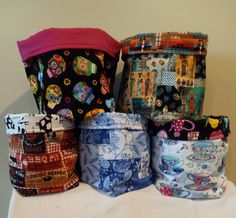 several different types of cloth bags sitting on top of a white table covered in fabric